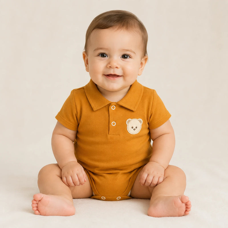 Bebê vestindo body Suedine Polo Manga Curta Bordado na cor ocre — NinaBoo ref. 5114